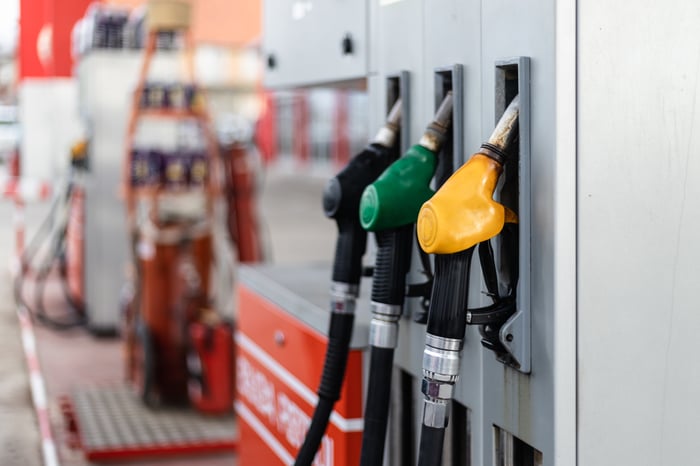 Three gas pumps are shown at a gas station.