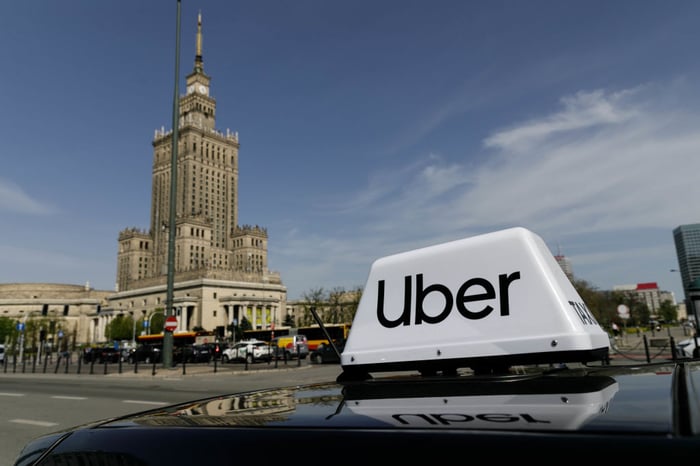 Uber sign and logo on top of car.