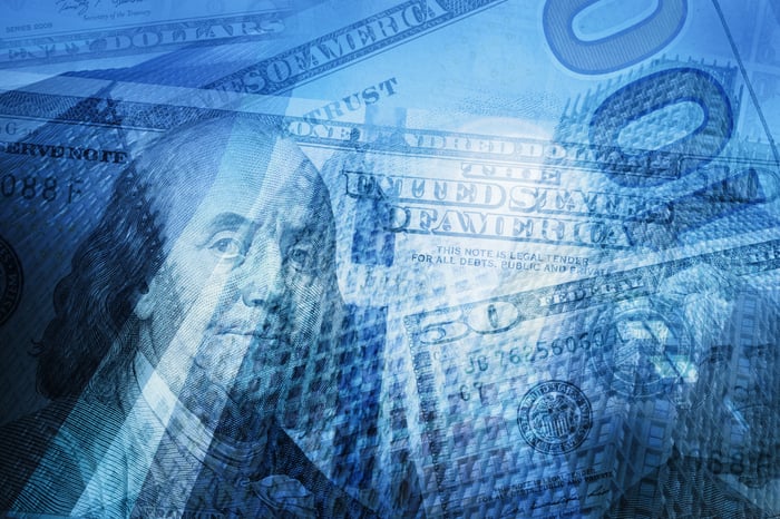 Cash superimposed over the image of a city skyline.