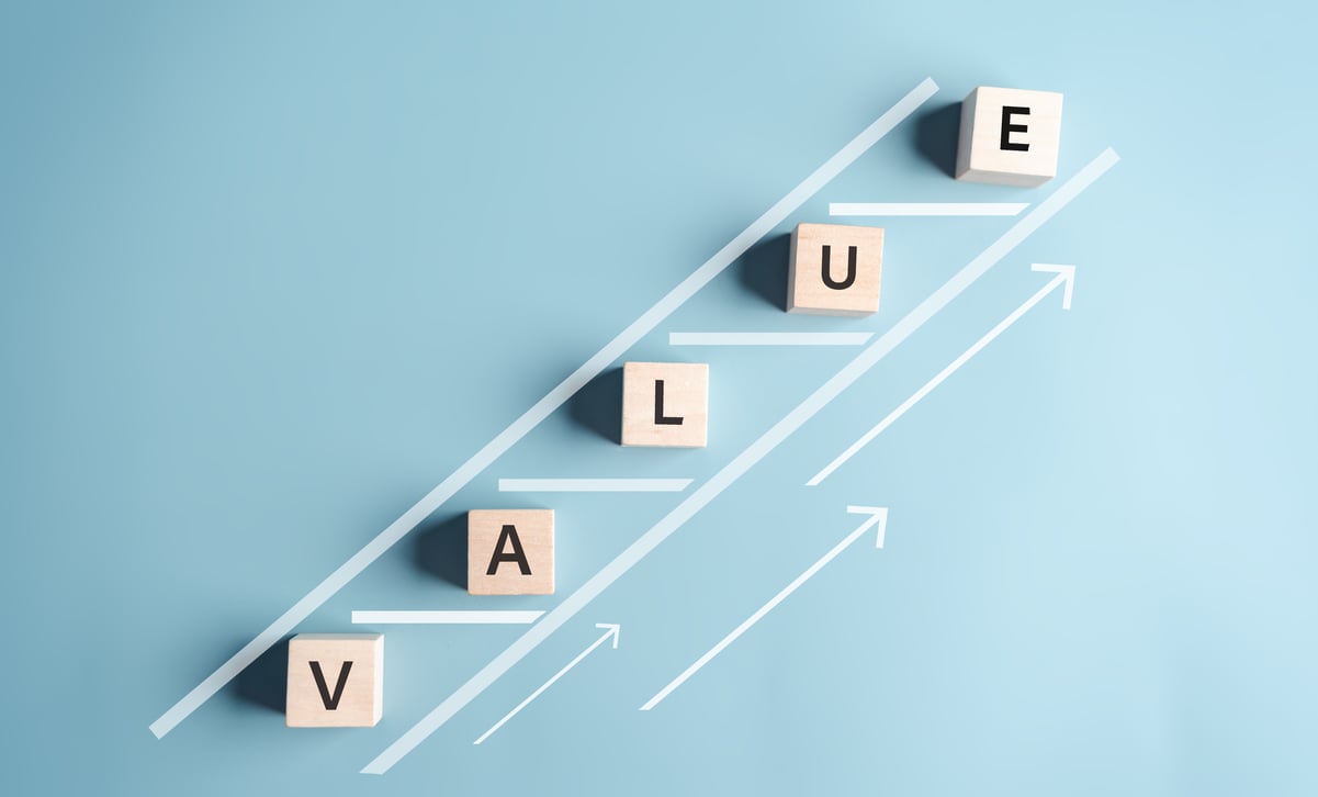 Wood blocks spell out “value” on an upward-sloping chart.