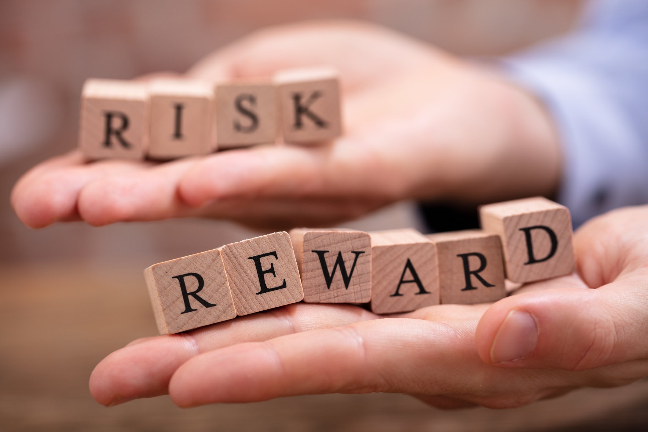 23_02_20 Hands holding blocks spelling risk and reward _MF Dload