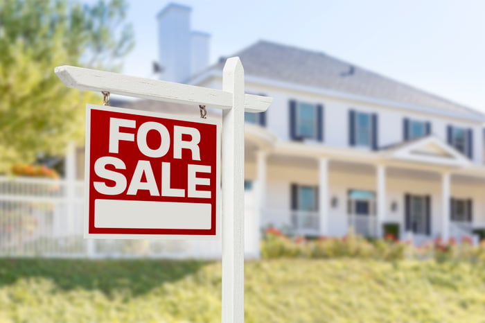 A house with a for sale sign in front.