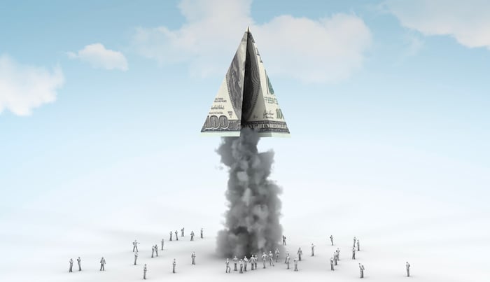 A hundred-dollar bill folded like a rocket and launching.
