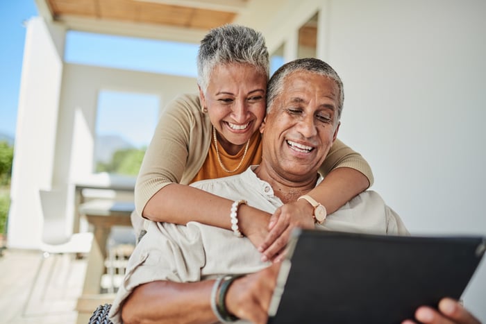 A couple looking happily at their laptop screen.
