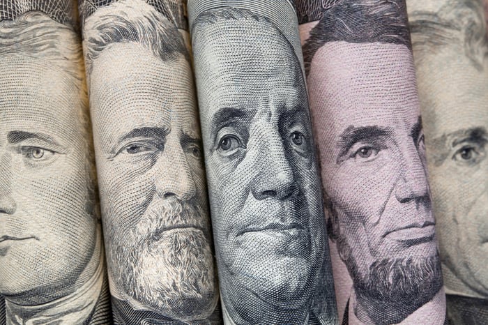 Rolled up money with faces showing.