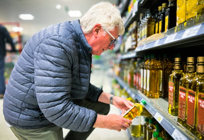 A shopper checking prices in a supermarket.