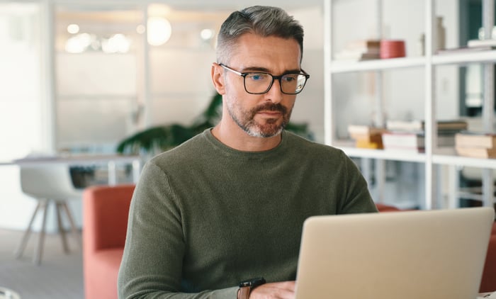 A person with a serious expression at a laptop.