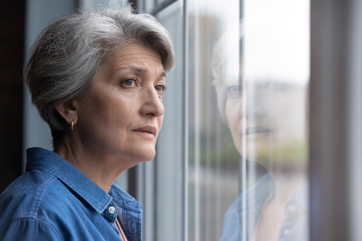 Stressed senior looking out window