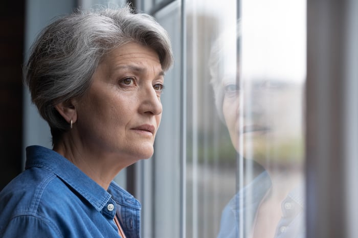 Stressed person looking out a window.