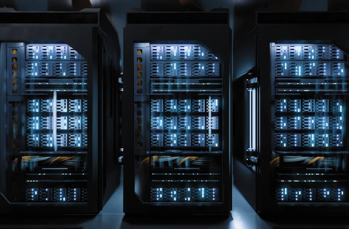 Data center racks lit up next to each other. 