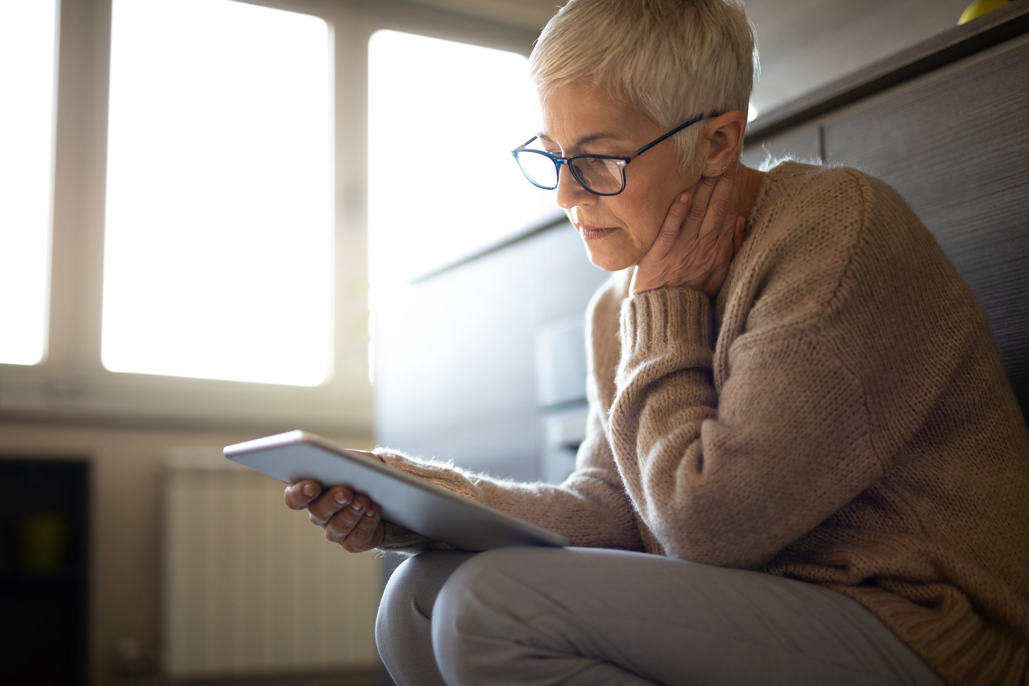 Senior woman holding tablet GettyImages-1133256480