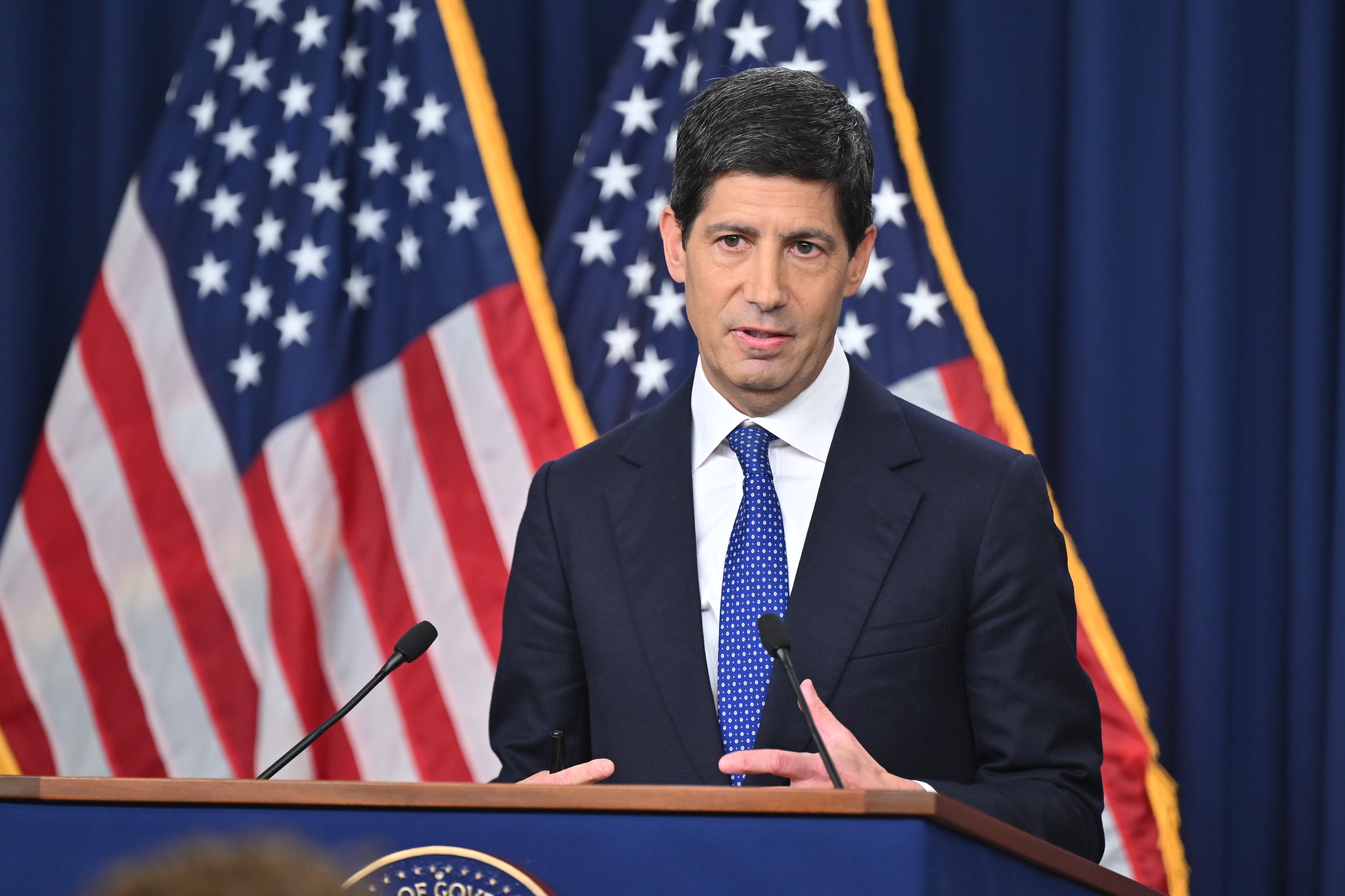 Kevin Warsh at the podium with American flags behind him source Federal Reserve