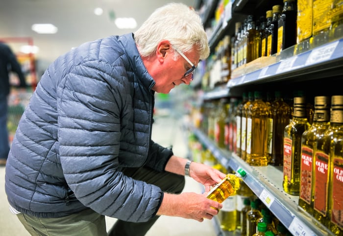 Someone picking up a product in a store aisle.