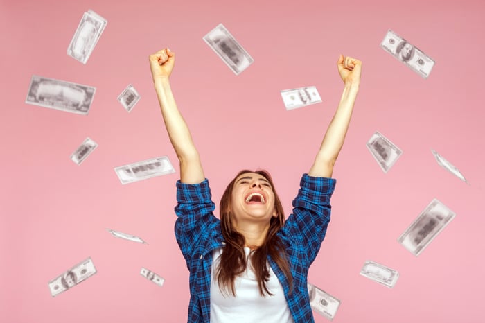 Investor celebrating a big win by throwing money in the air.