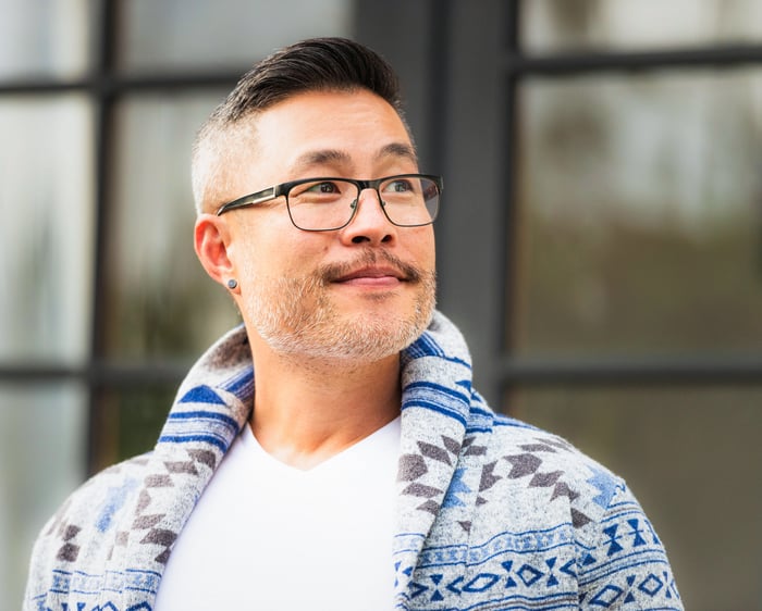Someone in a blue patterned jacket is outdoors and looking up.
