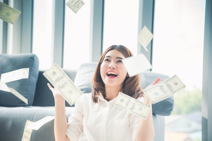 Investor throwing money in the air.