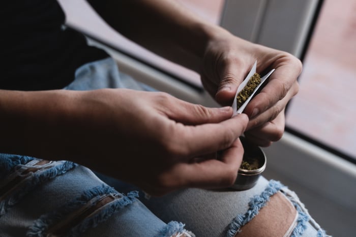 Pair of hands rolling a cigarette.