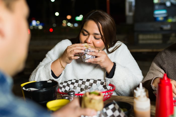 A woman eating a burger at a restaurant.