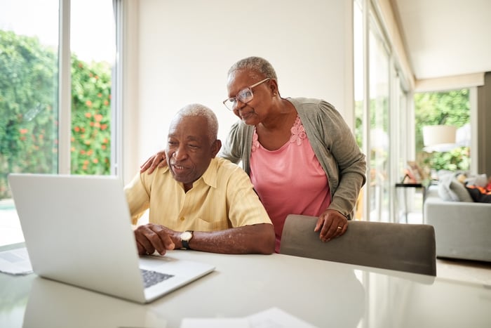 Two people looking at a laptop.