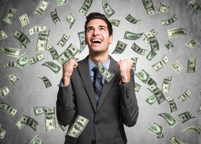 A happy person is showered with cash.