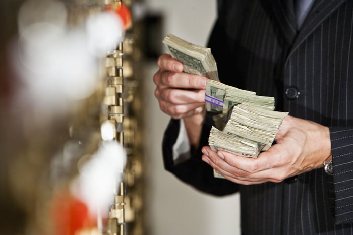 A banker is counting a stack of cash.