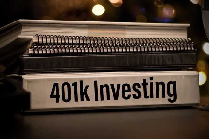 Stack of notebooks, with "401k Investing" printed on the spine of the bottom notebook. 