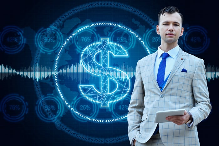 A business professional stands in front of a digital dollar representation. 