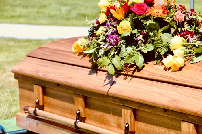 A casket covered with fresh flowers. 