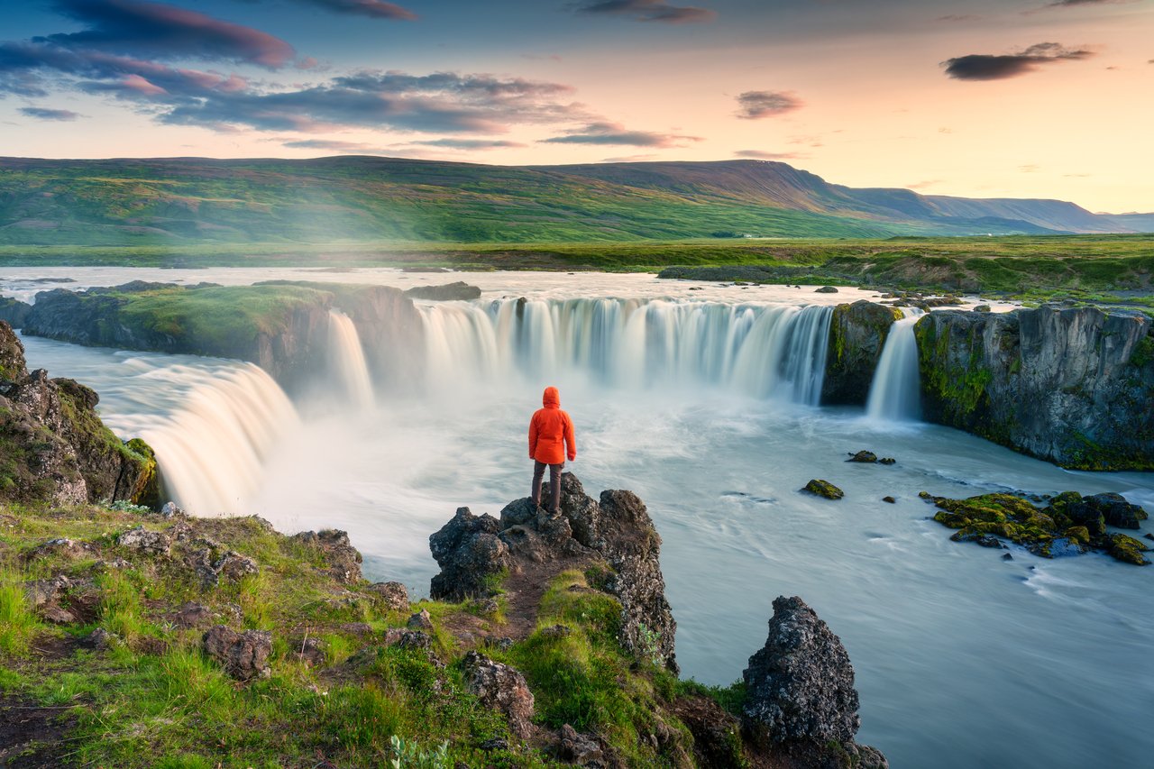 26_10_06 A person standing on a cliff overlooking a large waterfall system _MF Dload GettyImages-1629533738-1280x853-c533c3e