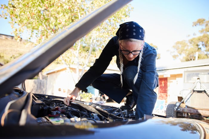 A person repairing a car. 
