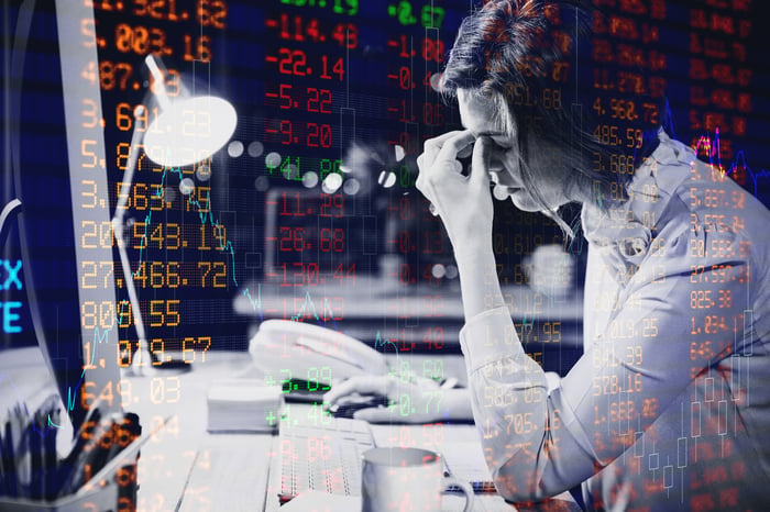 A weary investor reads stock information.