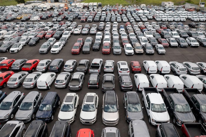 Cars and trucks for sale in a large lot.