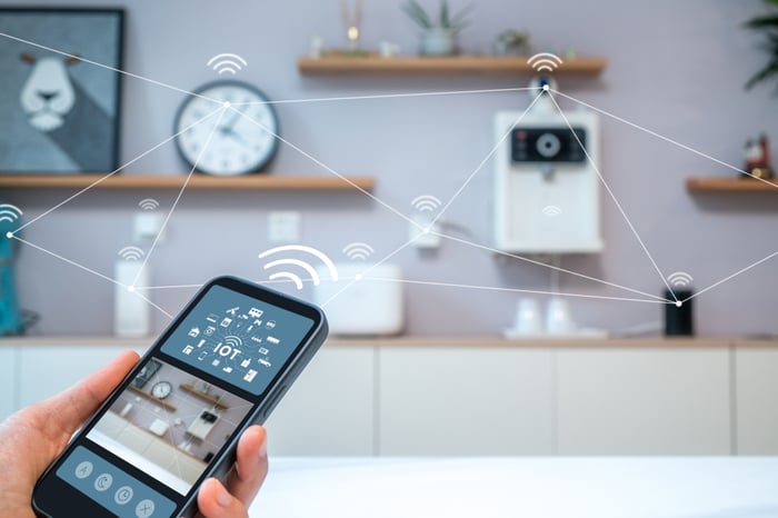 A person controlling home appliances from their phone.