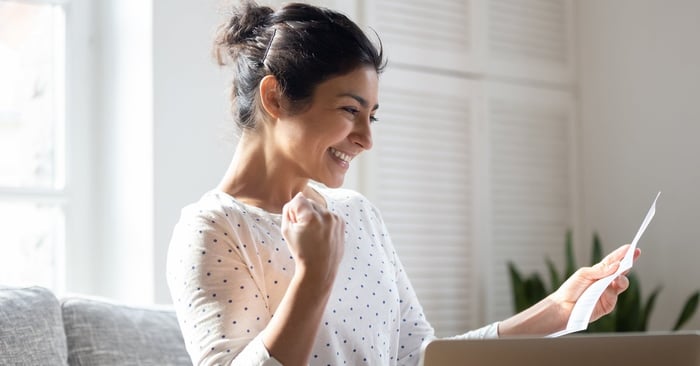 A woman pumps her fist and smiles.