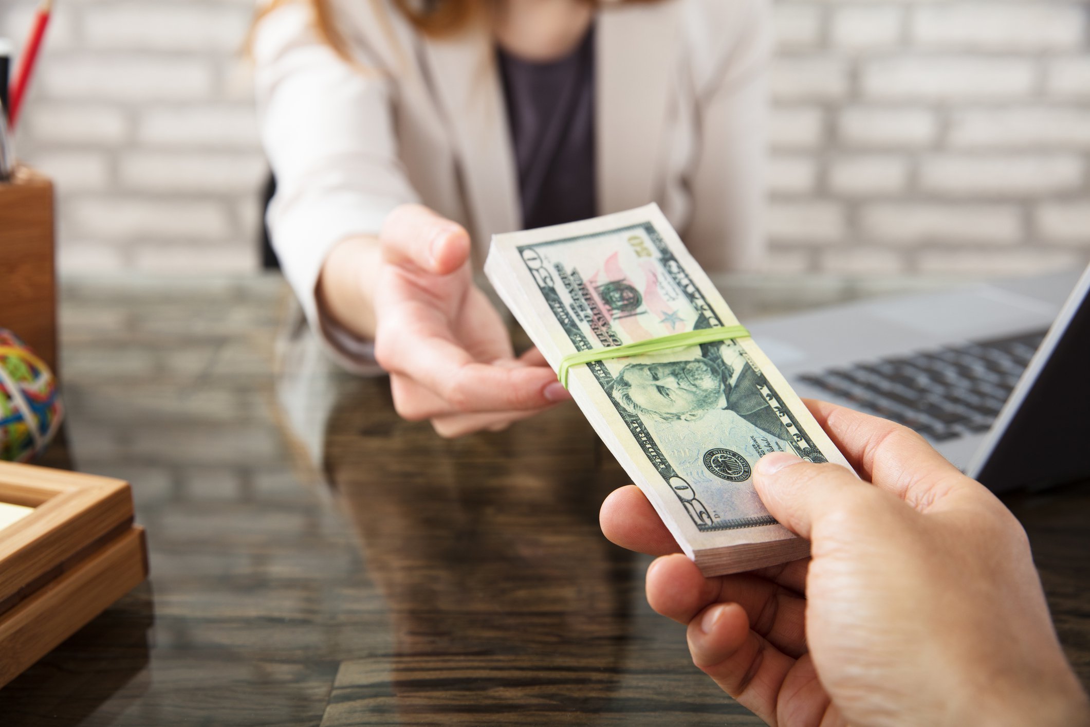 A person is handed a stack of cash.