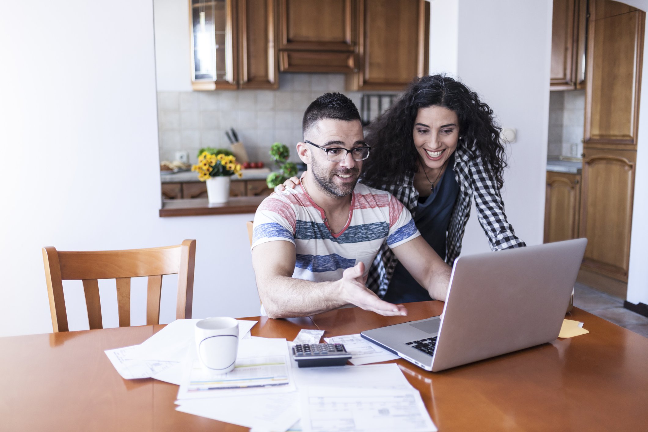 Couple working on their finances in a kitchen.