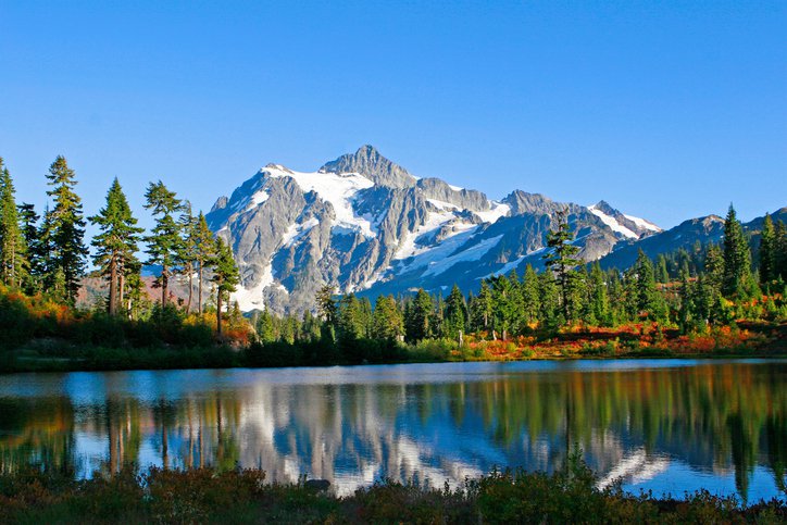 Mountains, lake, and trees, with blue skies on a sunny day.