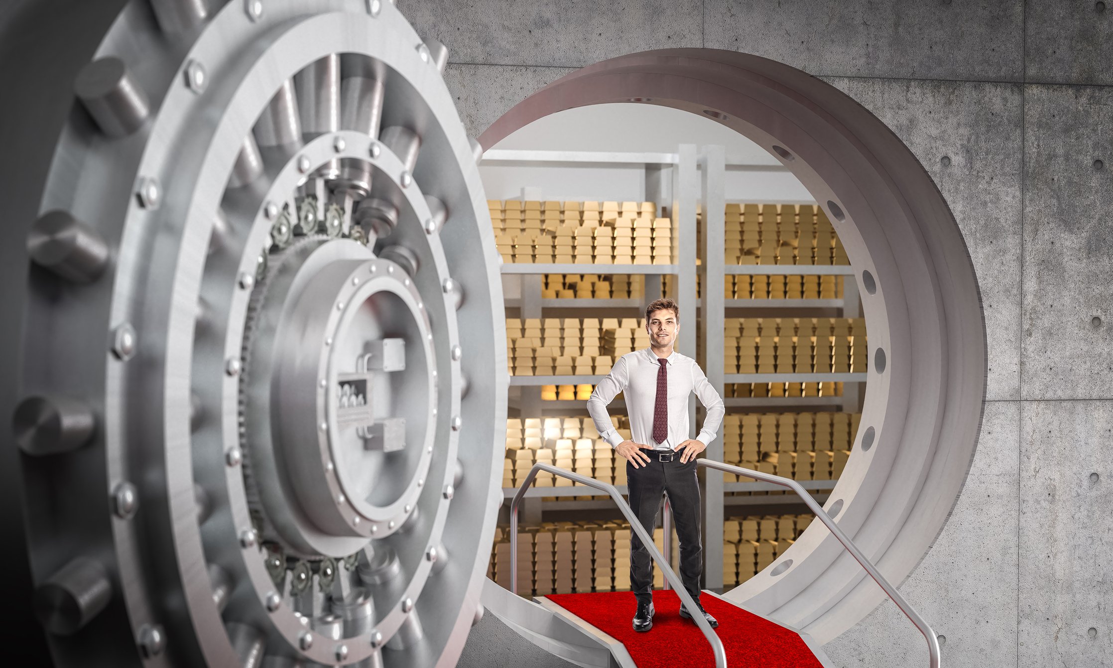 A man standing in a vault with gold bars behind him