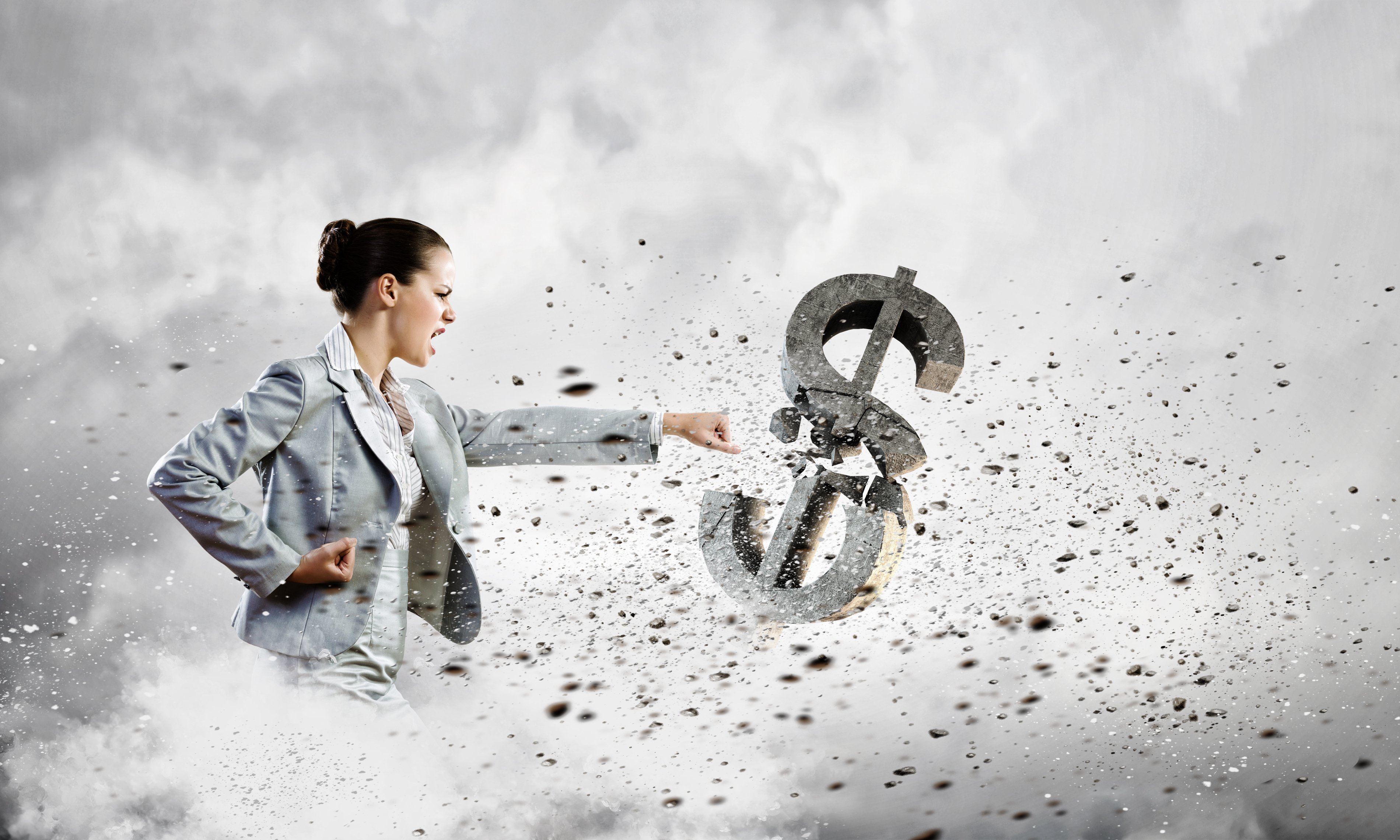 A woman in business attire punching a dollar sign that crumbles under her blow.