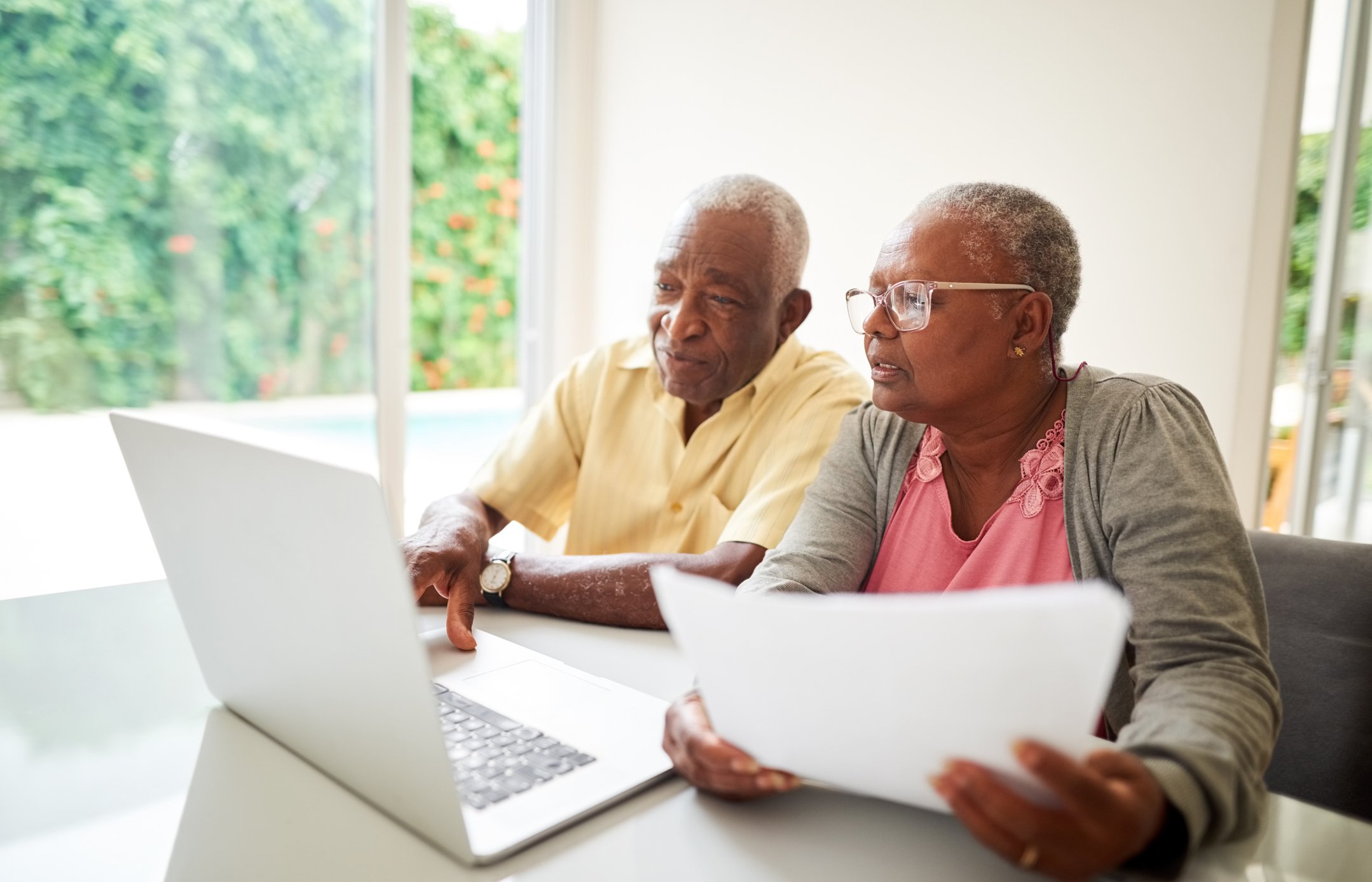 Retired couple looking at laptop and paperwork