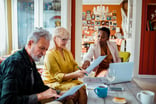 Couple signing paperwork with financial advisor.