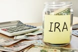 Jar of money labeled IRA sitting next to calculator