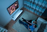 Couple watching tv in a darkened living room.