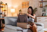Smiling person holding up shirt from package