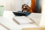Hands of person counting on calculator
