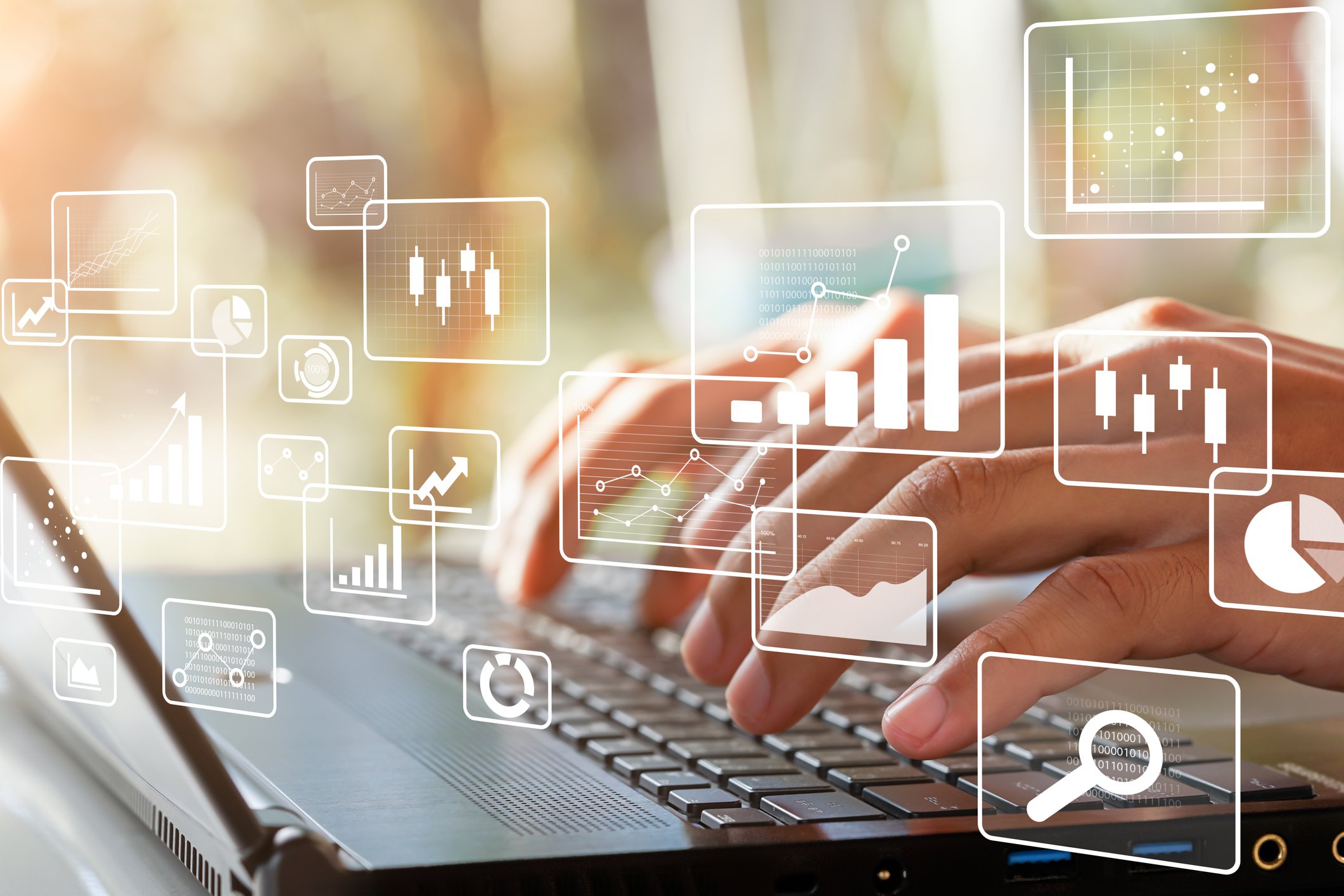 Hands on laptop keyboard with business intelligence icons displayed in foreground.