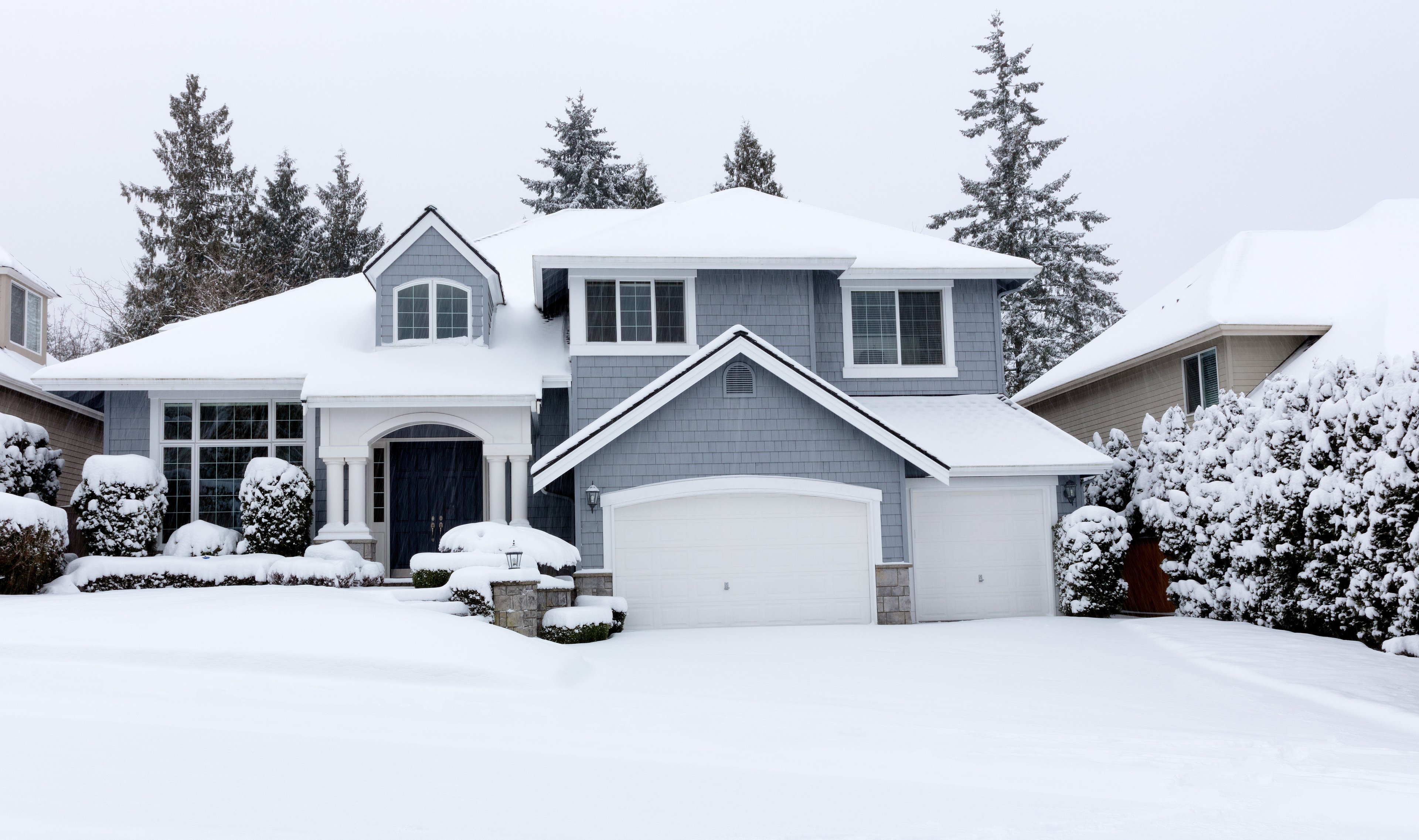 A house in the winter blanketed with snow.