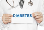 Physician holding up a paper reading Diabetes.