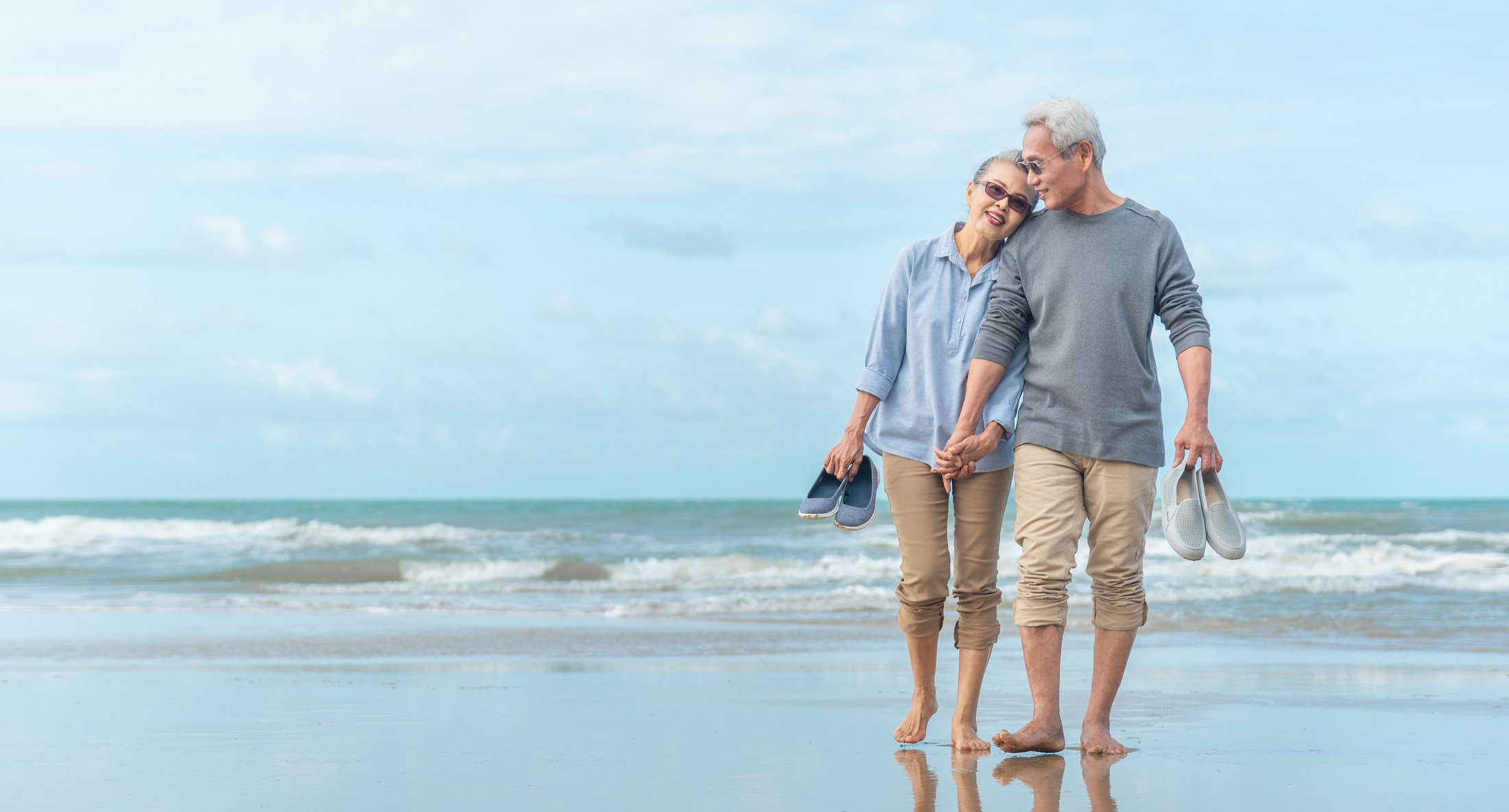 Retired couple walking on beach