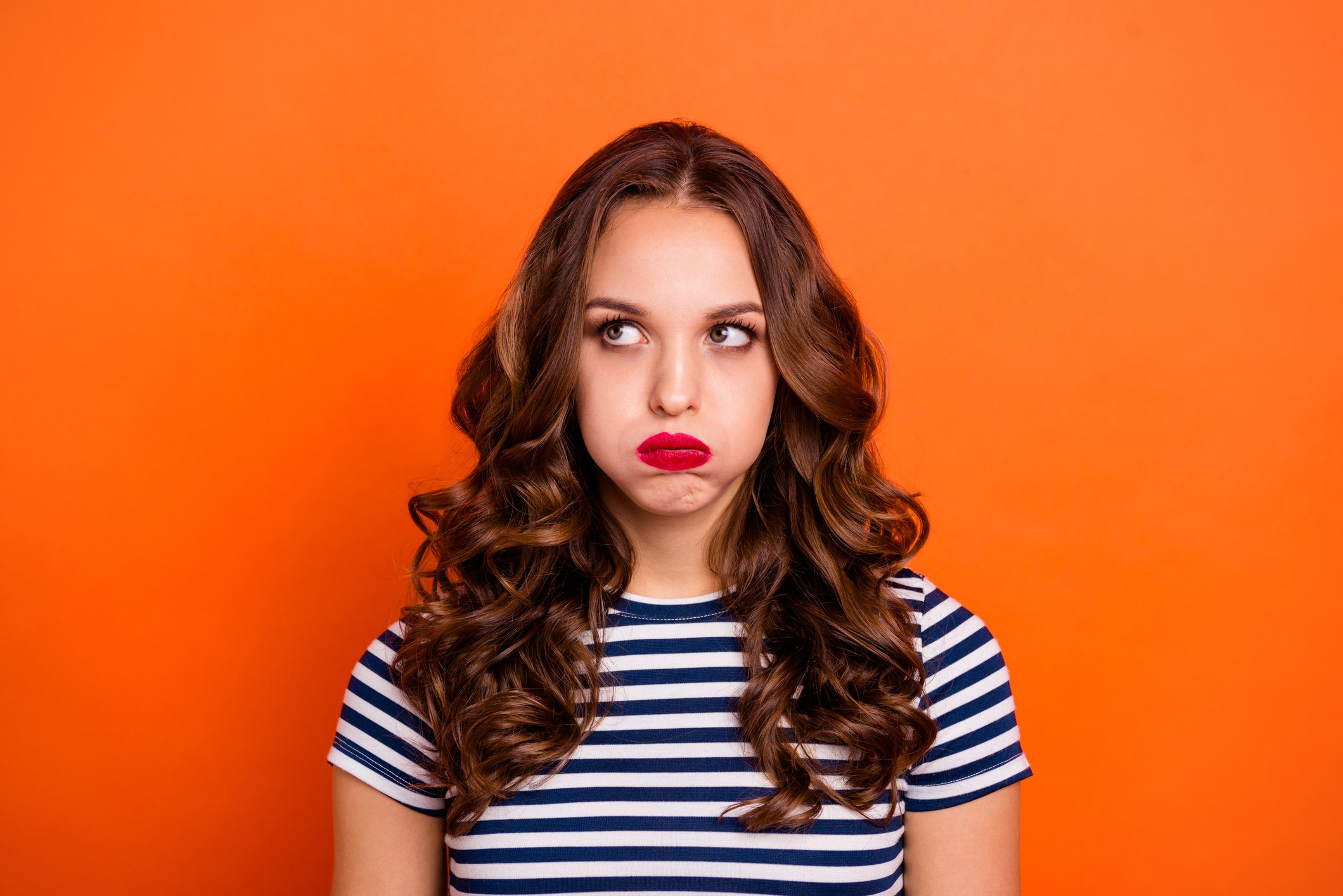 Woman in striped shirt pouting and looking disappointed